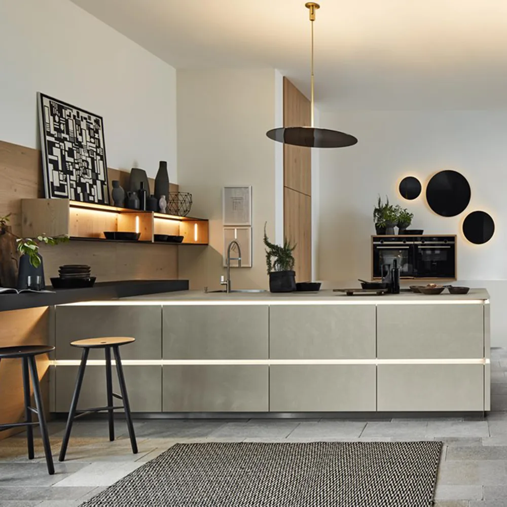 Cocina alemana a medida en gris arena con iluminación LED y detalles en madera expuesta en el showroom Per Sé Küchen Valladolid
