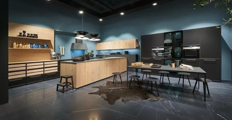 Cocina alemana a medida en madera natural con paredes en azul, isla central y zona de comedor integrada